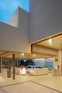 Modern living room featuring concrete elements and a view of the ocean.