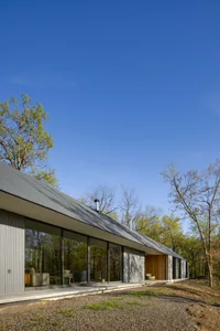 Modern minimalist metal building with large windows and a flat roof.