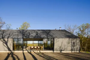 Modern residential building with metal siding and large glass windows.
