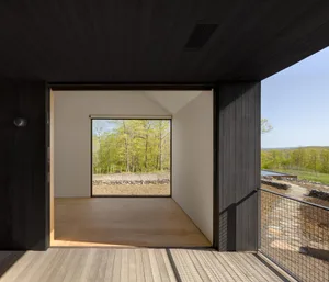 Modern residential interior with large window overlooking trees.