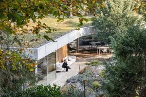 A modern house exterior made of concrete with a minimalist design, surrounded by greenery.