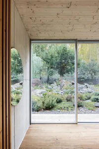 Modern interior featuring a glass window overlooking a garden
