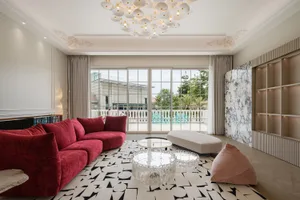 Modern living room with velvet cushions, marble coffee table, and patterned rug