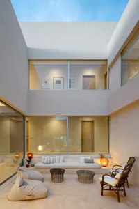 Modern living room featuring glass walls and minimalist furniture.