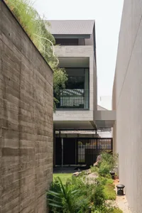 A modern residential home with a concrete exterior and large glass windows.