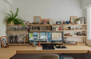 A well-organized workspace featuring a variety of sculptures and decorative items arranged on a wooden desk.