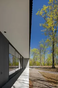 A minimalist residential house exterior featuring modern architectural elements and large glass windows.