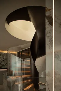 A modern indoor staircase featuring glass and metal