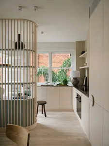 Modern kitchen featuring wooden cabinets, sleek countertops, and a large window overlooking greenery.