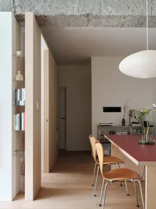 Modern minimalist kitchen dining space featuring wood, concrete, and metal materials.