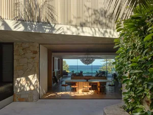 Modern minimalist living room featuring natural stone walls and wooden flooring.