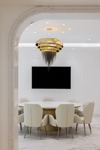A modern conference room with a circular table, white chairs, and a white marble finish.