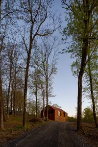 Rustic house with a red exterior surrounded by trees