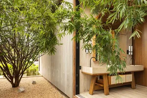 A modern bathroom featuring concrete walls and a wooden sink with a natural stone countertop.