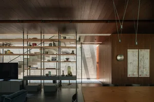 A modern dining room featuring wooden shelving with various decorative items.