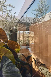 An interior space featuring modern design elements, including glass walls and wooden accents.