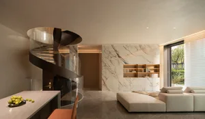 Modern residential space featuring a luxurious marble kitchen counter with a spiral staircase and a contemporary white sofa.