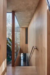 A modern interior with a wooden staircase and glass wall, featuring a sleek, contemporary design.