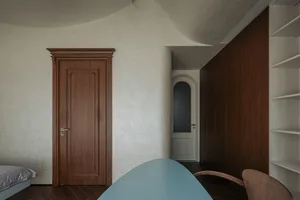 A modern kitchen interior featuring wooden cabinets and floors.