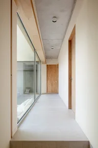 Modern minimalist corridor with large glass windows and a concrete floor