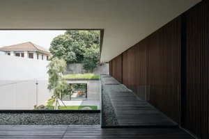 Modern patio featuring concrete, glass, and wooden elements.