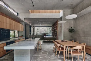 A modern residential kitchen featuring a concrete and wood interior design.