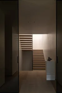 A modern staircase interior with wooden steps and illuminated railings.