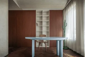 現代書房空間，藍色桌面搭配木質椅子、木質與白色書櫃，以及木質牆板