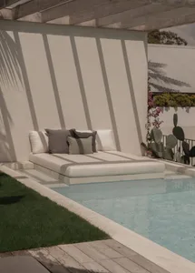 Concrete poolside lounge with cushions.