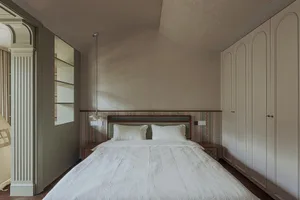 A modern bedroom featuring textured wallpaper and soft lighting.