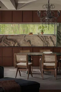 A modern dining room featuring a marble table and wooden chairs.