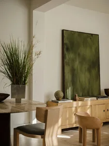 A modern dining room with wood furniture and a plant