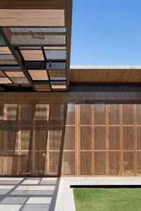 Modern architectural exterior featuring wooden slat walls and an open patio area.