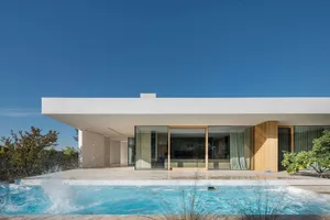 A modern house featuring concrete walls and a pool outdoors.