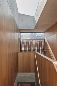A modern interior design featuring wooden walls and concrete structural elements.