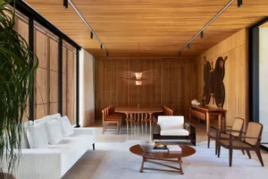 A modern living room with wooden furniture, a white sofa, and a wooden table.