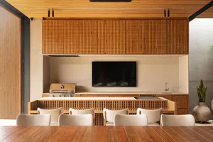A modern residential kitchen with concrete countertops and wooden cabinets and furniture.