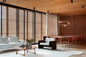 Modern living room with white furniture, wooden ceiling, and large windows