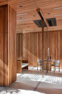 A modern office interior featuring wooden walls, floors, and furniture.