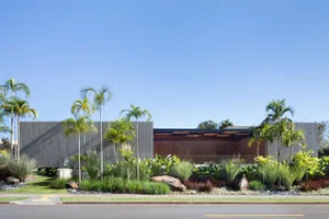Modern residential exterior featuring wooden, stone, and glass materials.