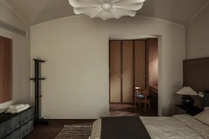 A bedroom that uses neutral colors, wood, leather, and fabric.