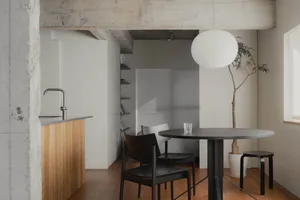 Industrial-style office space with concrete walls, exposed beams, and minimalist furniture.