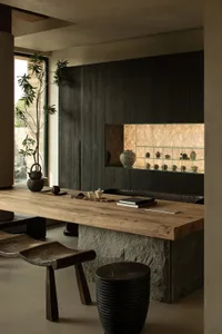 A minimalist residential interior featuring wood, stone, and glass materials.