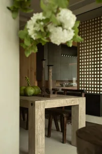 Modern dining room with wooden table and stone surface, featuring modern decor elements like wooden chairs and minimalist des