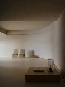 A modern minimalist interior space featuring concrete furniture and flooring.