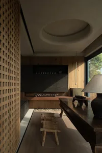 A modern living room featuring wood paneling, minimalist design, and natural light.