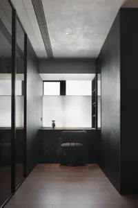 Modern minimalist workspace featuring black wooden surfaces and a minimalist design aesthetic.