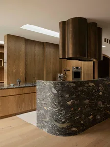 A modern industrial kitchen with wooden cabinets and granite/marble countertops.