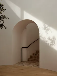 Modern, minimalist staircase with marble steps and handrail in a light-filled space.
