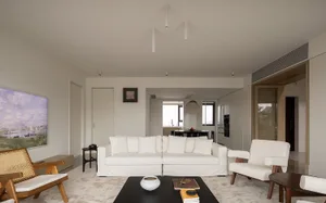 A minimalist living room with white furniture and neutral-tones decor.